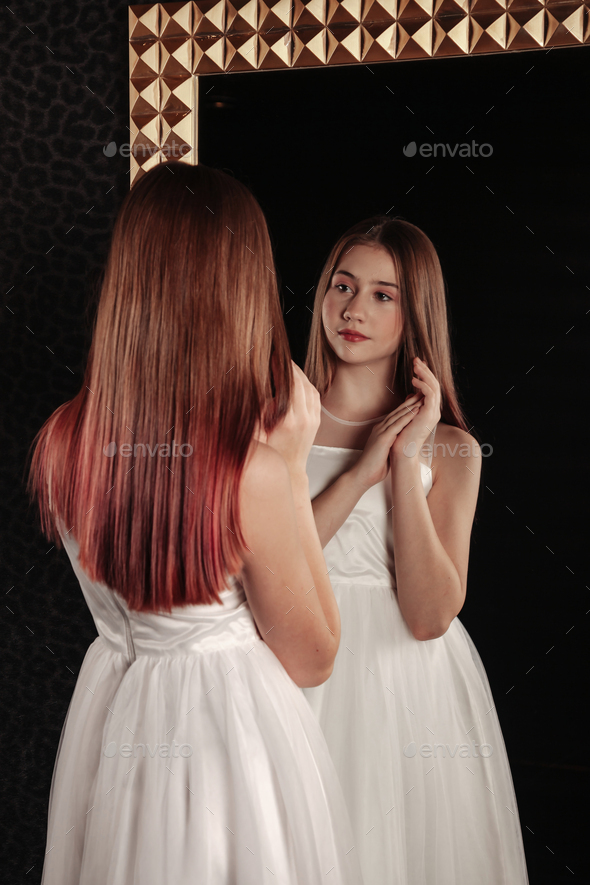 Teenager standing and posing, looking at reflection. Portrait cute teen